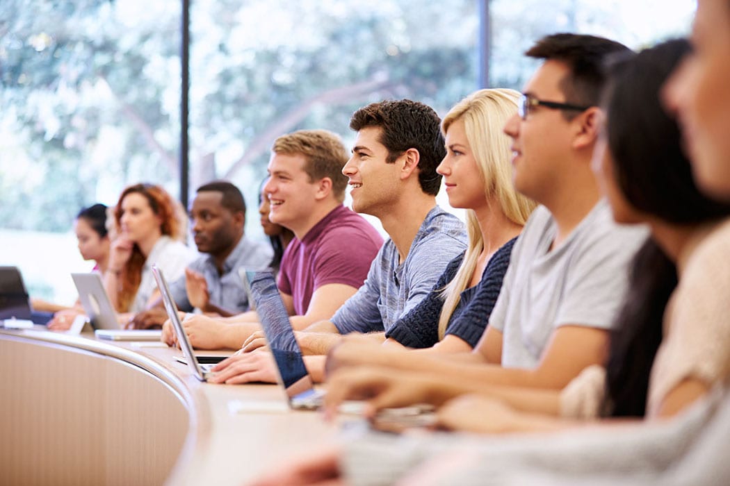 Group of multi-racial students smiling in class